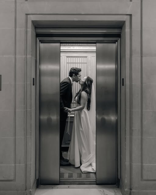 A black and white wedding portrait framed by a doorway