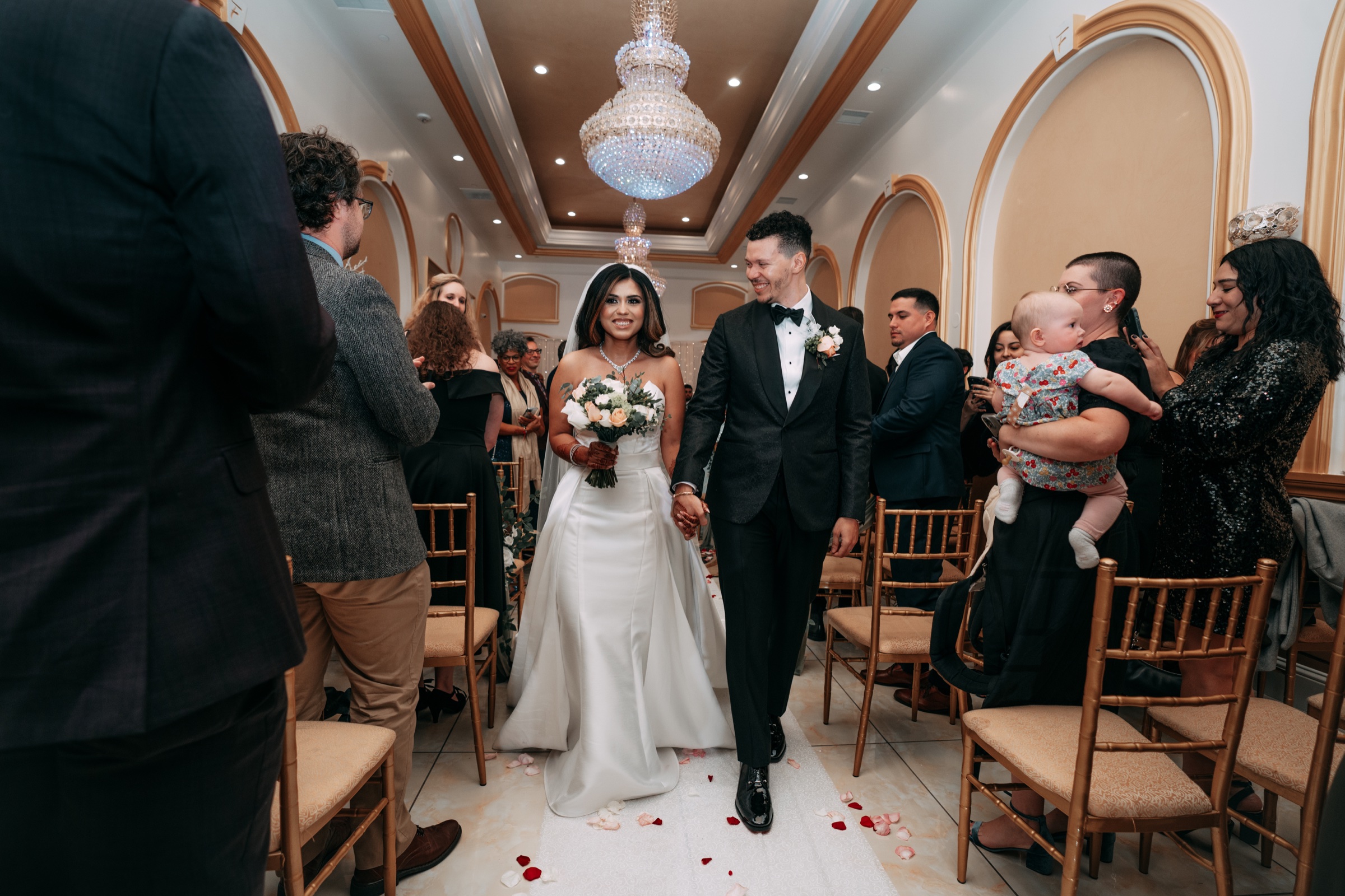 The couple walking down the aisle after their ceremony
