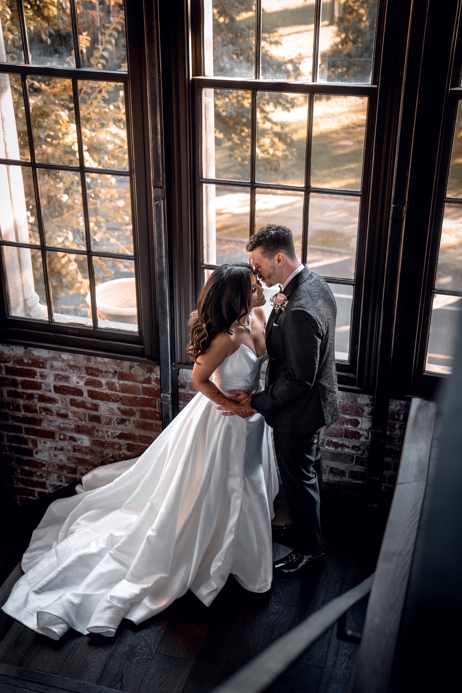 A full-length wedding portrait in the window light