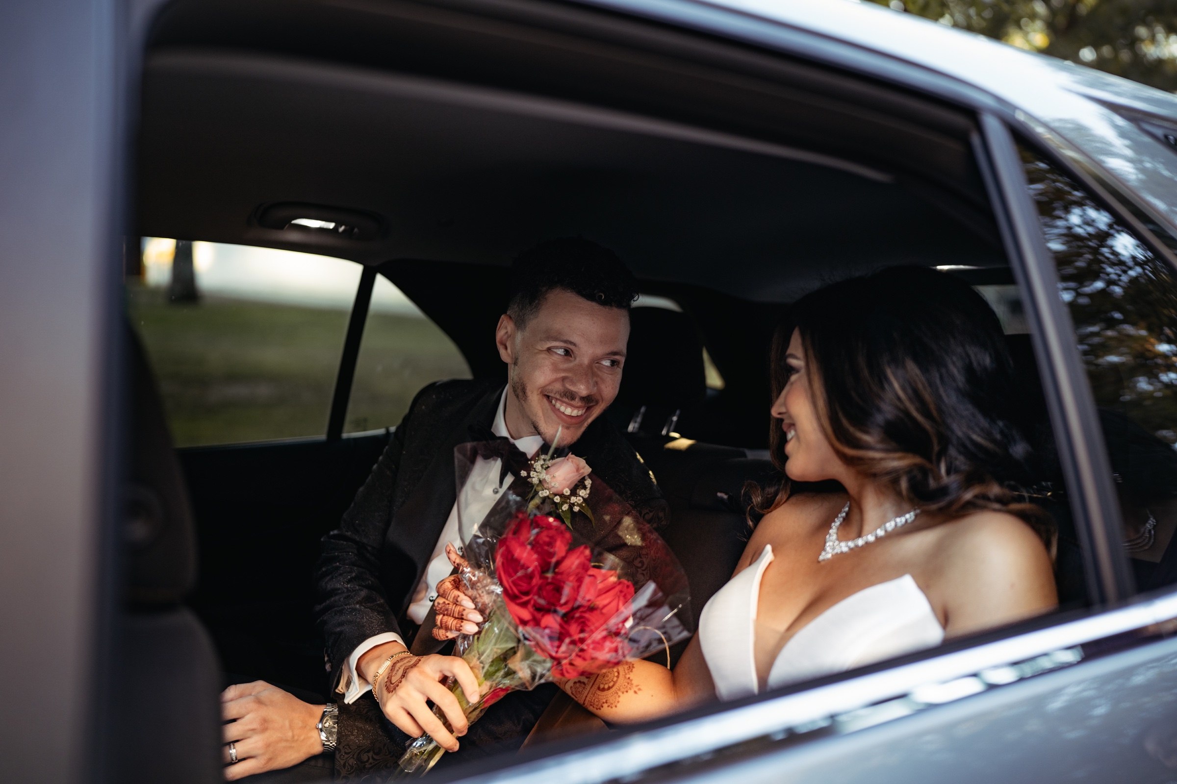 The newlyweds smiling together in their car